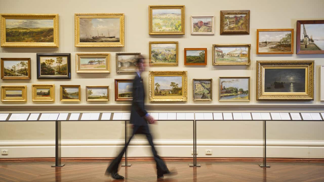 Blurred view of Caucasian security guard walking in art museum