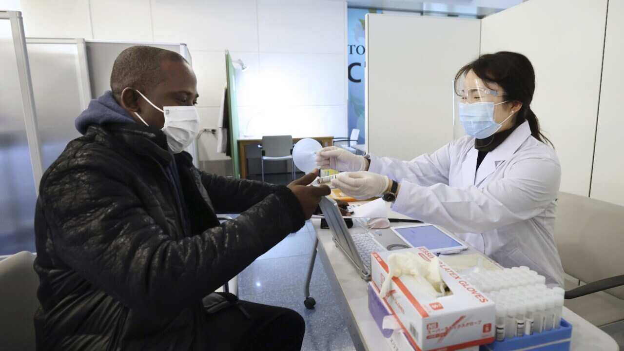A preflight coronavirus test underway at Haneda International Airport in Tokyo (AAP)