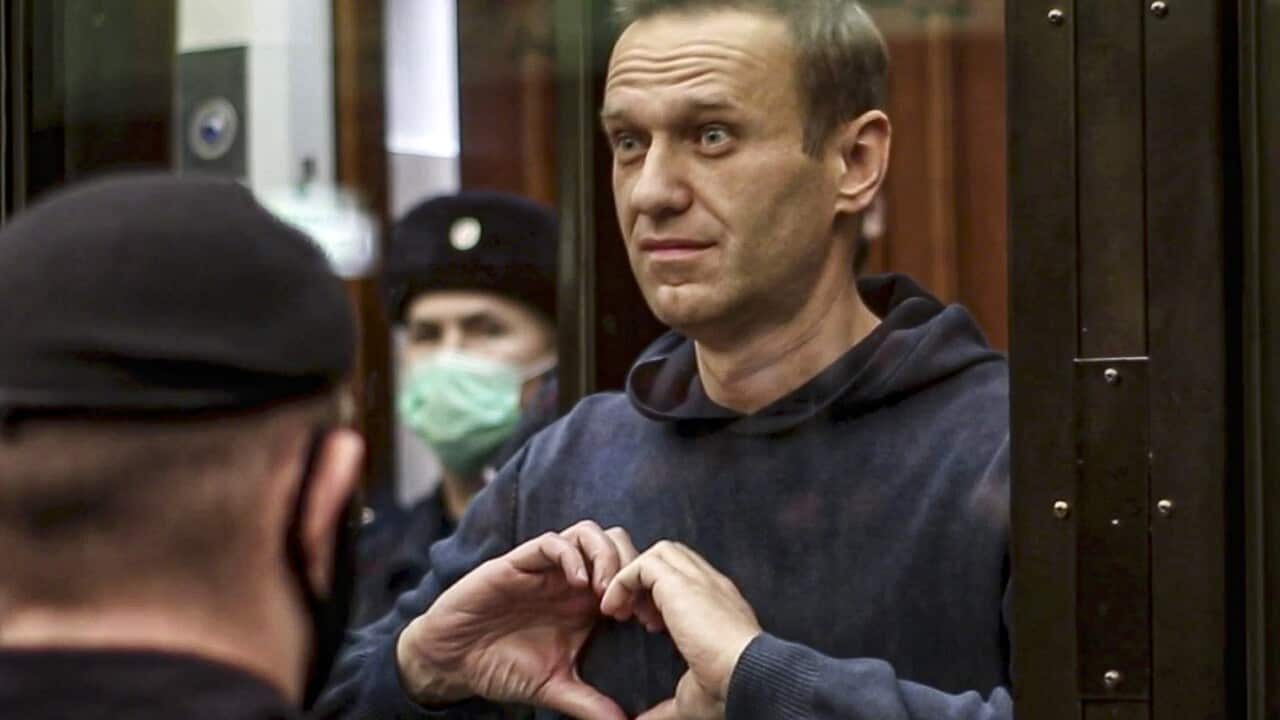 Russian opposition leader Alexei Navalny shows the heart symbol from the cage, during a hearing at the City Court in Moscow, Russia, 21 February, 2021.