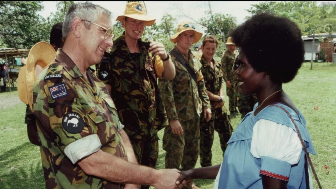 New Zealand Defence Force Brigadier Roger Mortlock shakes hands with a Bougainvillean woman.