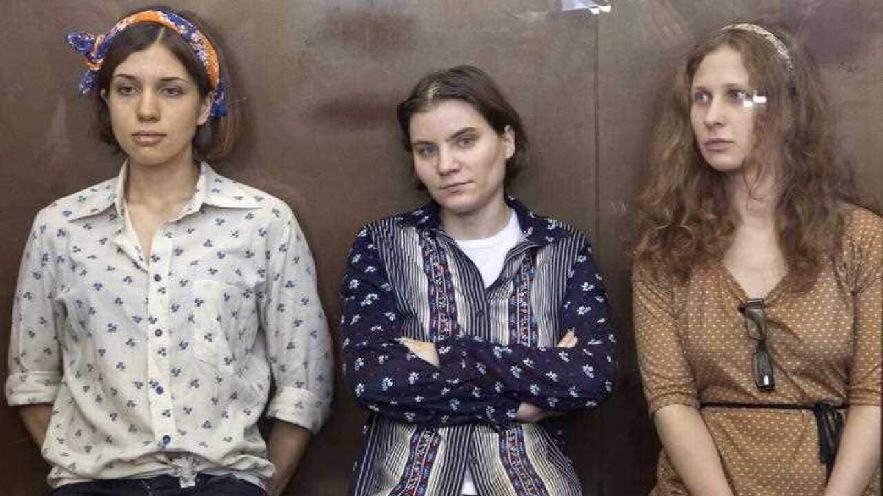 Pussy Riot members, from left, Nadezhda Tolokonnikova, Yekaterina Samutsevich and Maria Alekhina sit in a glass cage at a court room in Moscow, Russia, Friday, Aug. 3, 2012.