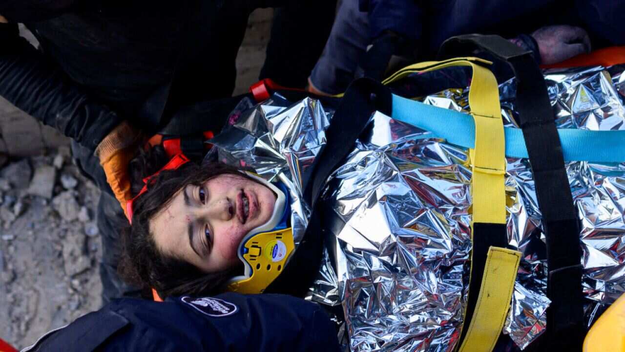 A 12-year-old Syrian girl, Cudi, is evacuated by rescuers from the rubble of a destroyed building in Hatay, Türkiye.