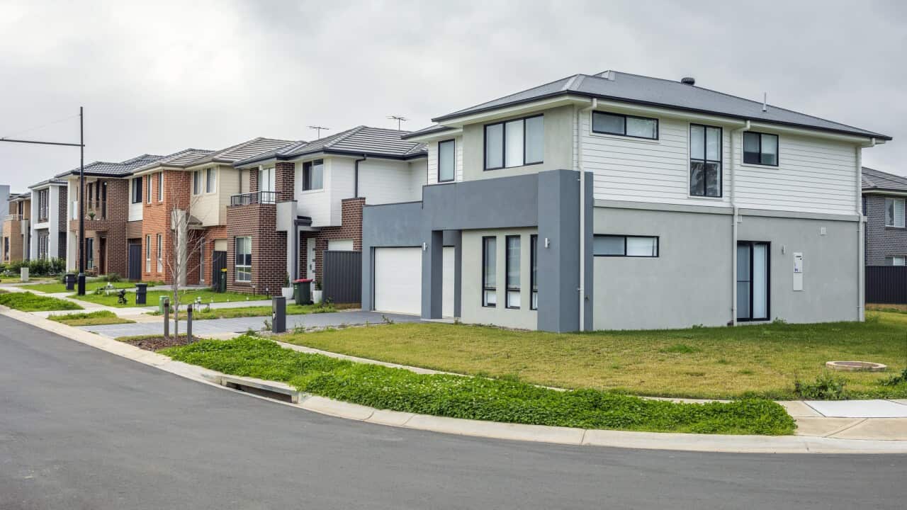 New houses in suburban street, rain clouds overcast sky