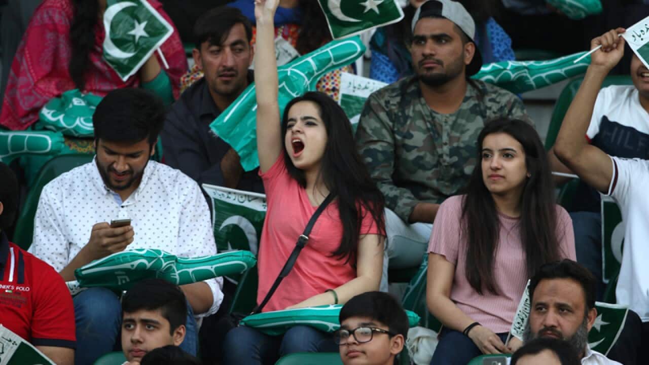 Pakistani supporters wave national flags at the cricket