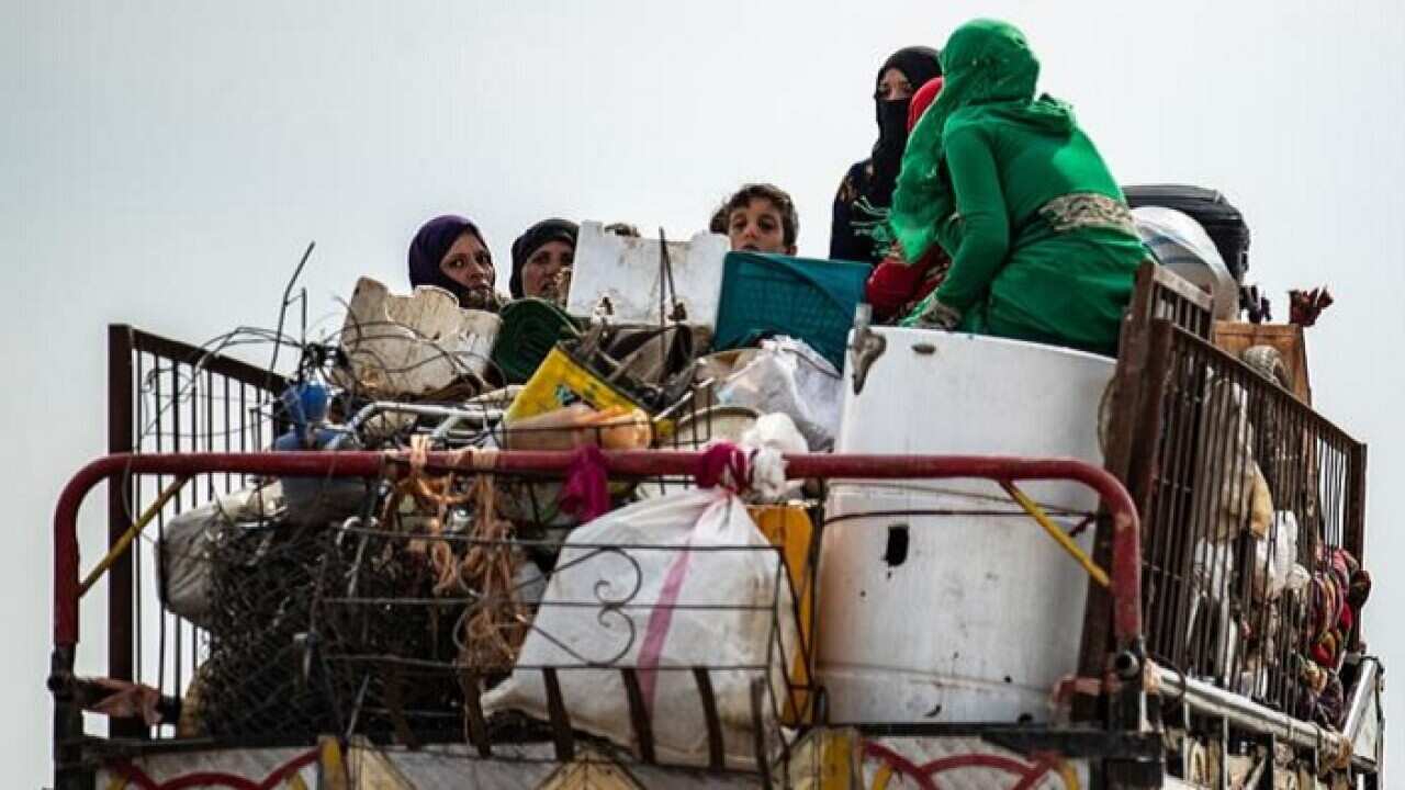 Syrian Kurdish and Arab families fleeing in the countryside of the town of Darbasiyat on the border between Syria and Turkey.