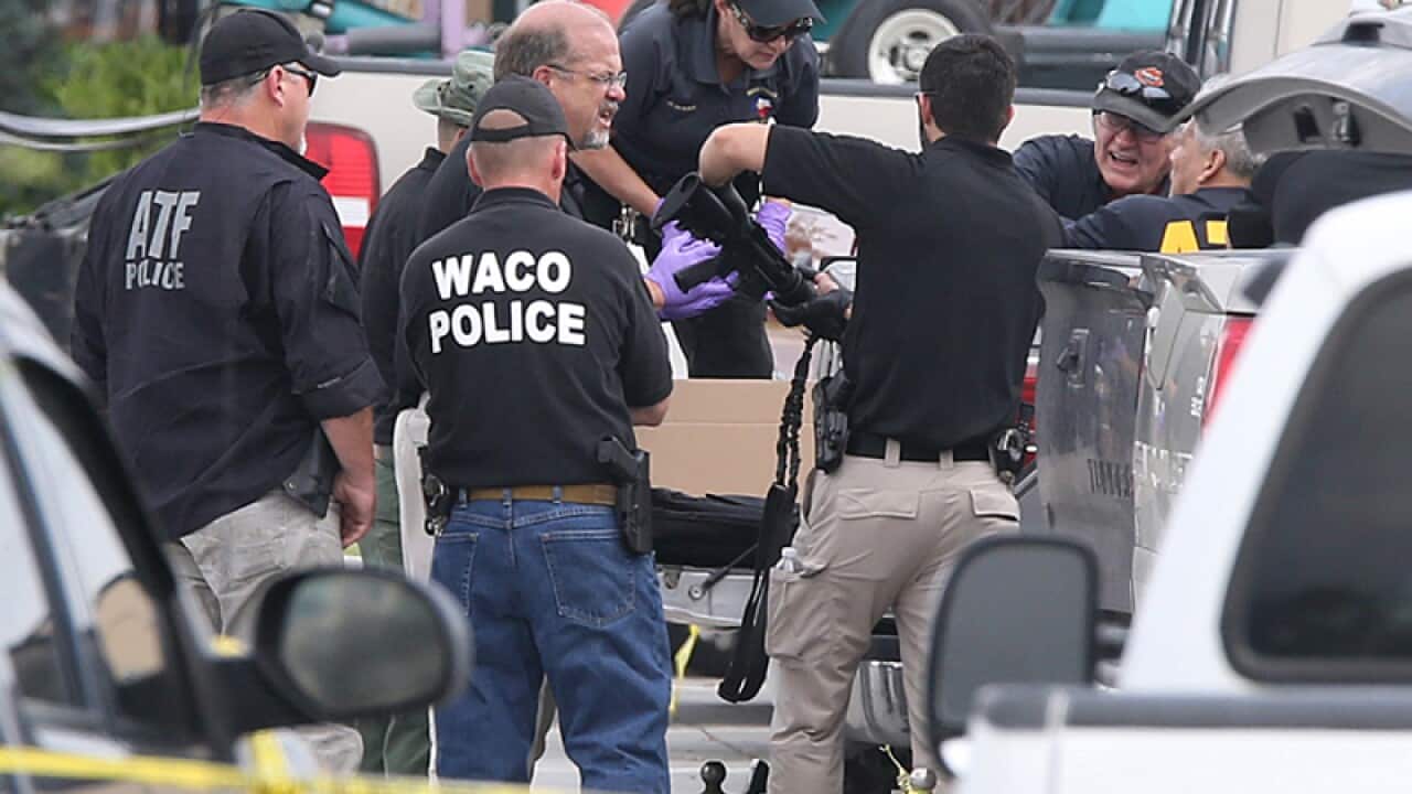 Police recover a weapon from a vehicle in a parking lot