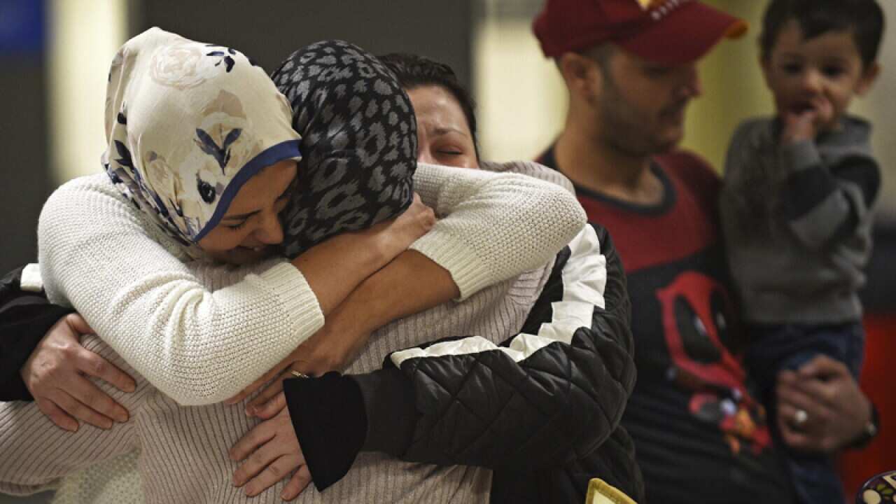 An Iraqi family welcome their grandmother at an airport