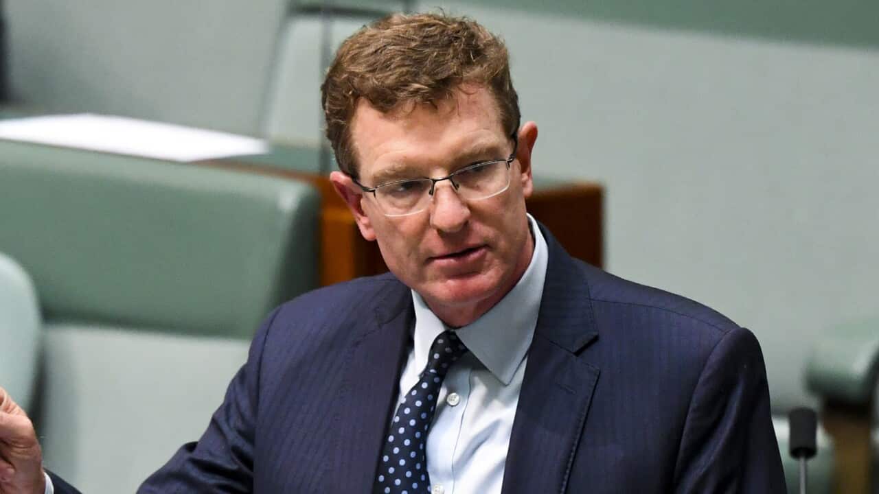 A man wearing a suit and tie standing while speaking in the House of Representatives.