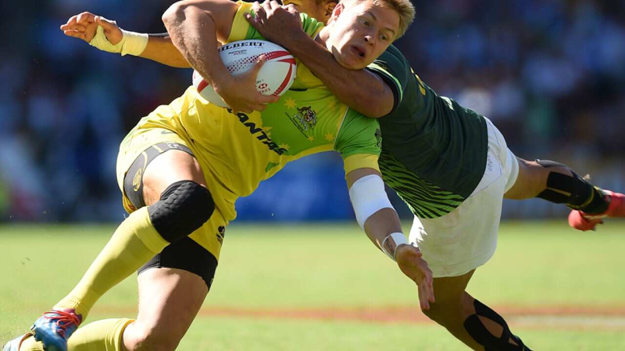 Tom Kingston of Australia is tackled by Juan de Jongh of South Africa