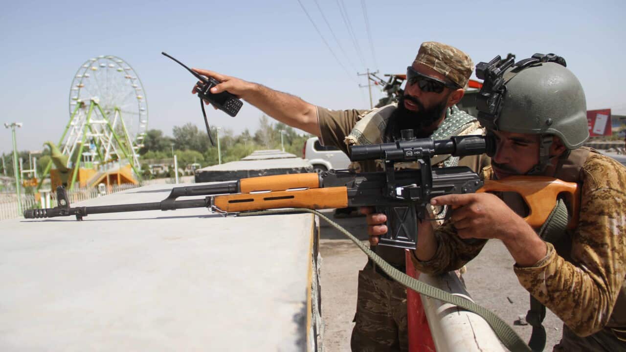 Afghan security officials stand guard at a roadside check point in Herat, Afghanistan, 31 July 2021.