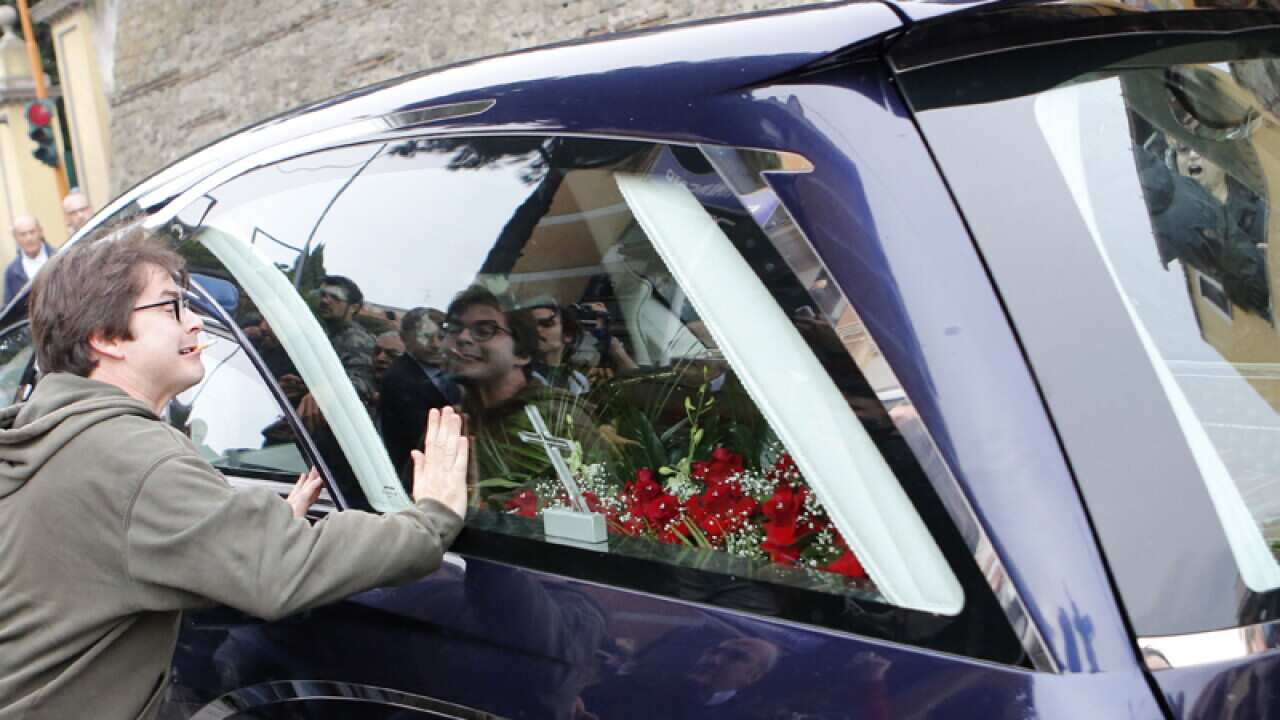 A protester bangs on the hearse carrying the coffin of Erich Priebke