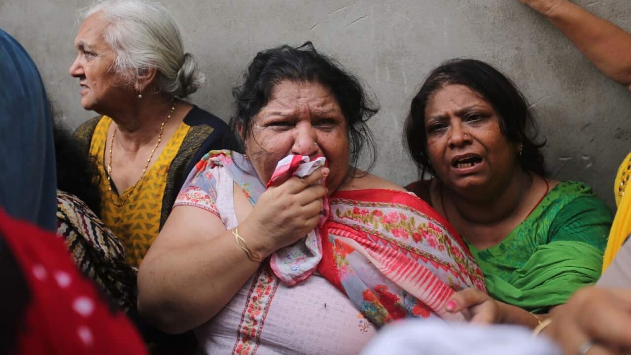Relatives mourn the death of 11 members of a family that were found dead in New Delhi.