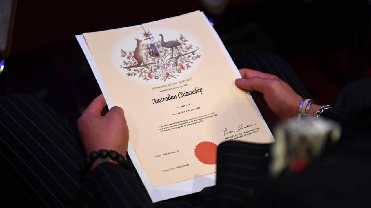 An Australian citizenship recipient holds his certificate during a citizenship ceremony on Australia Day in Brisbane, Thursday, Jan. 26, 2017. (AAP Image/Dan Peled) NO ARCHIVING