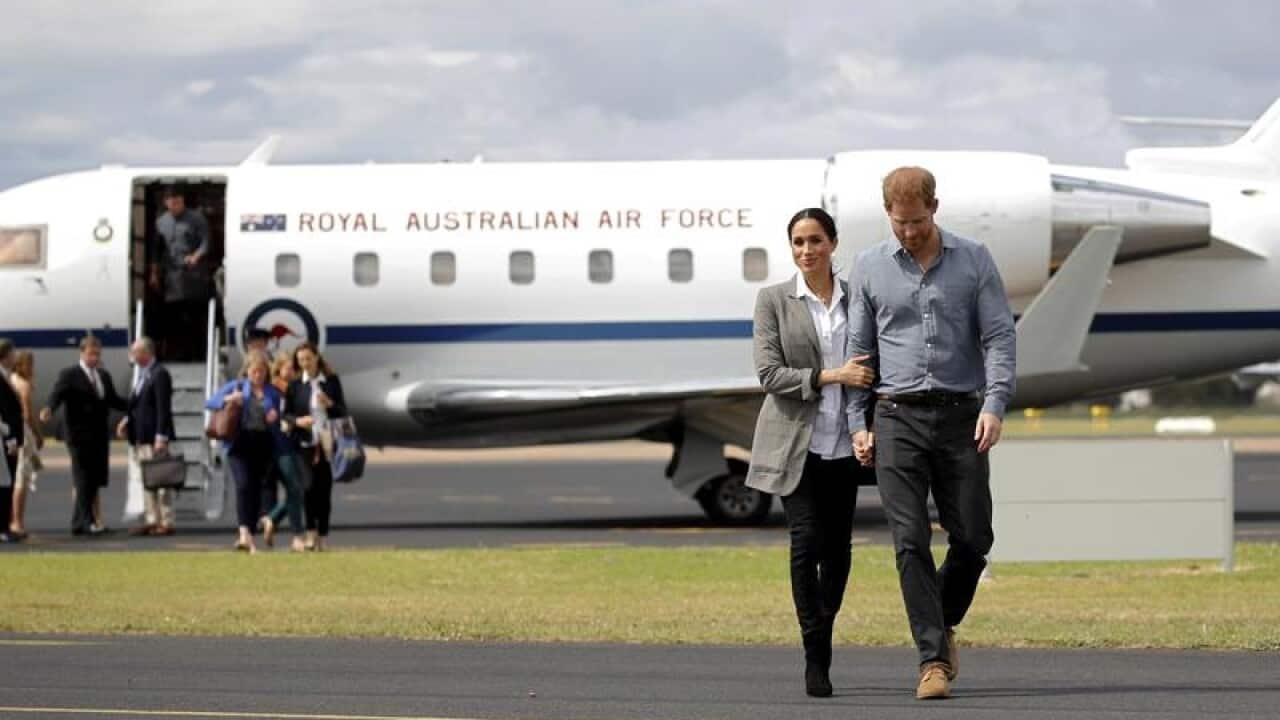Prince Harry and Meghan arrive in Dubbo, holding hands.