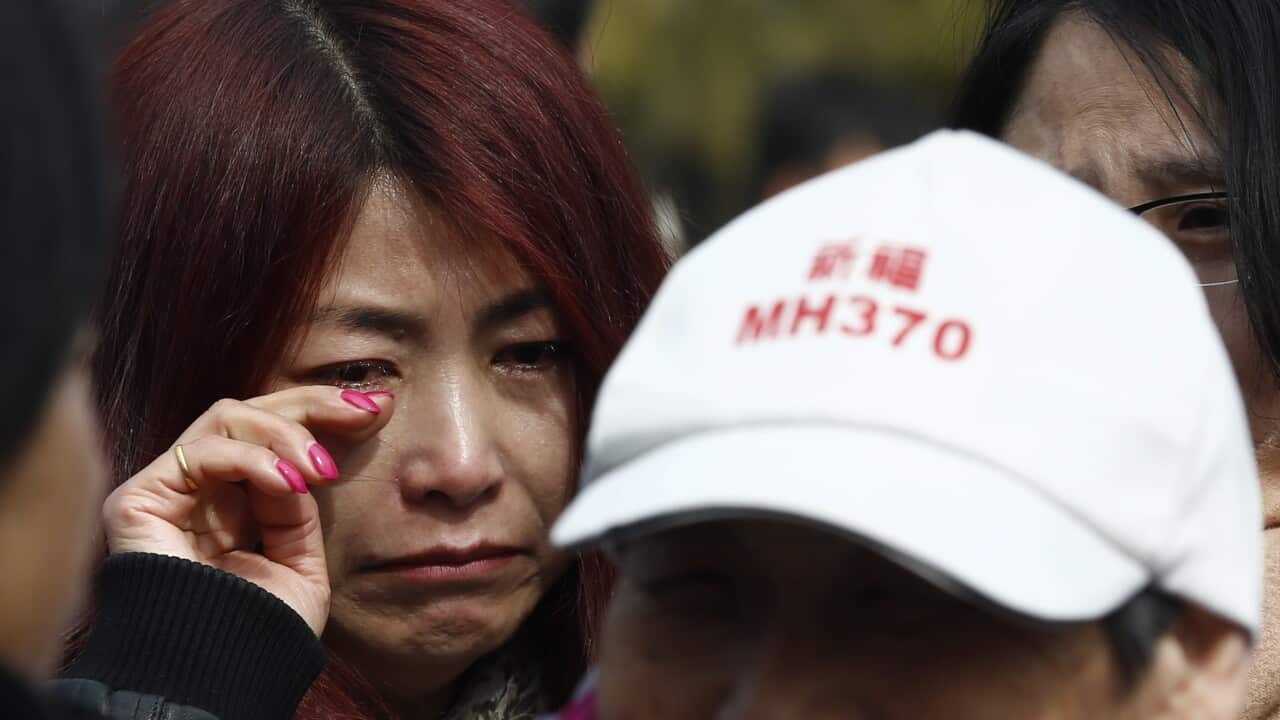 A relative of passengers of Malaysia Airlines flight MH370 cries outside the Yonghegong Lama Temple in Beijing, China