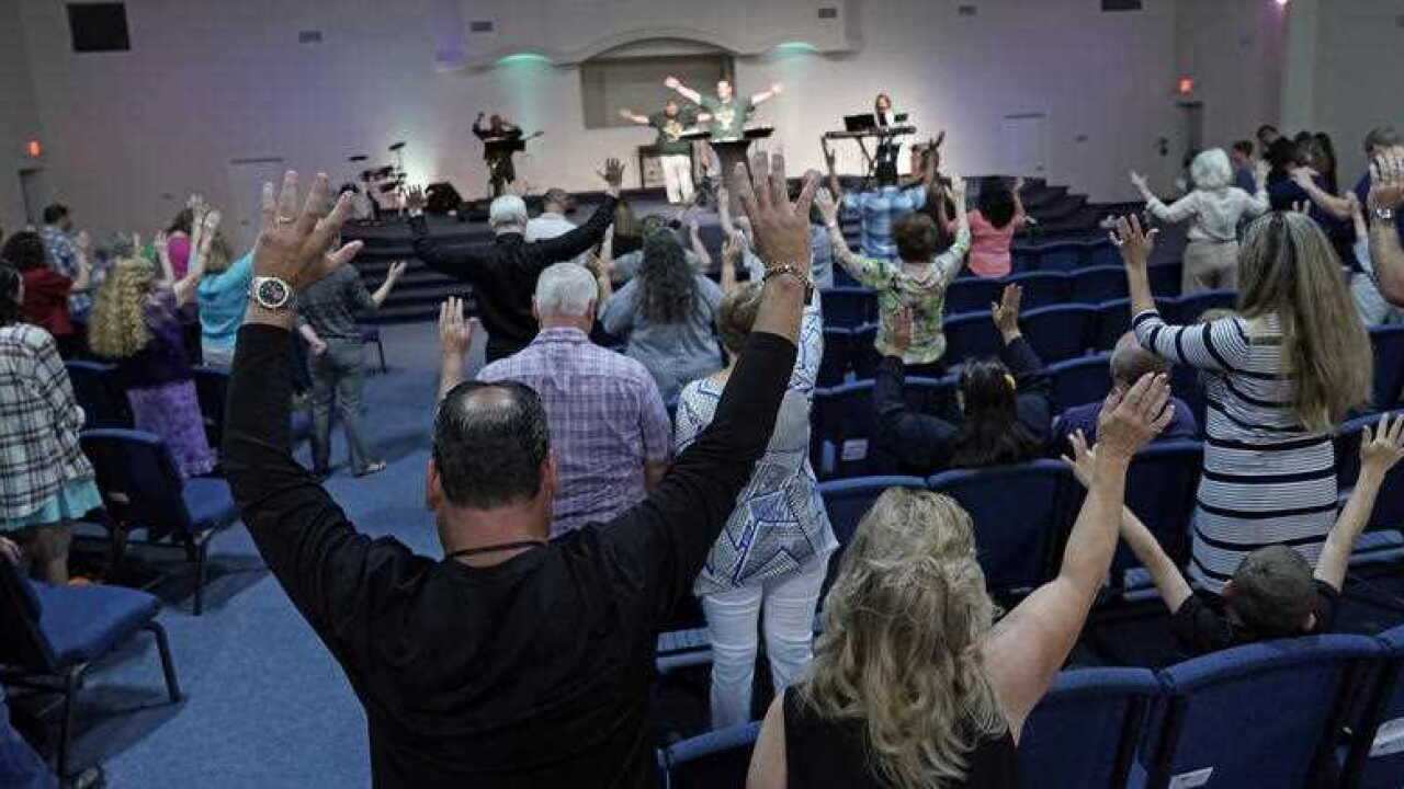 Members of the Dayspring Church raise their hands in prayer Sunday, May 20, 2018, in Santa Fe, Texas.