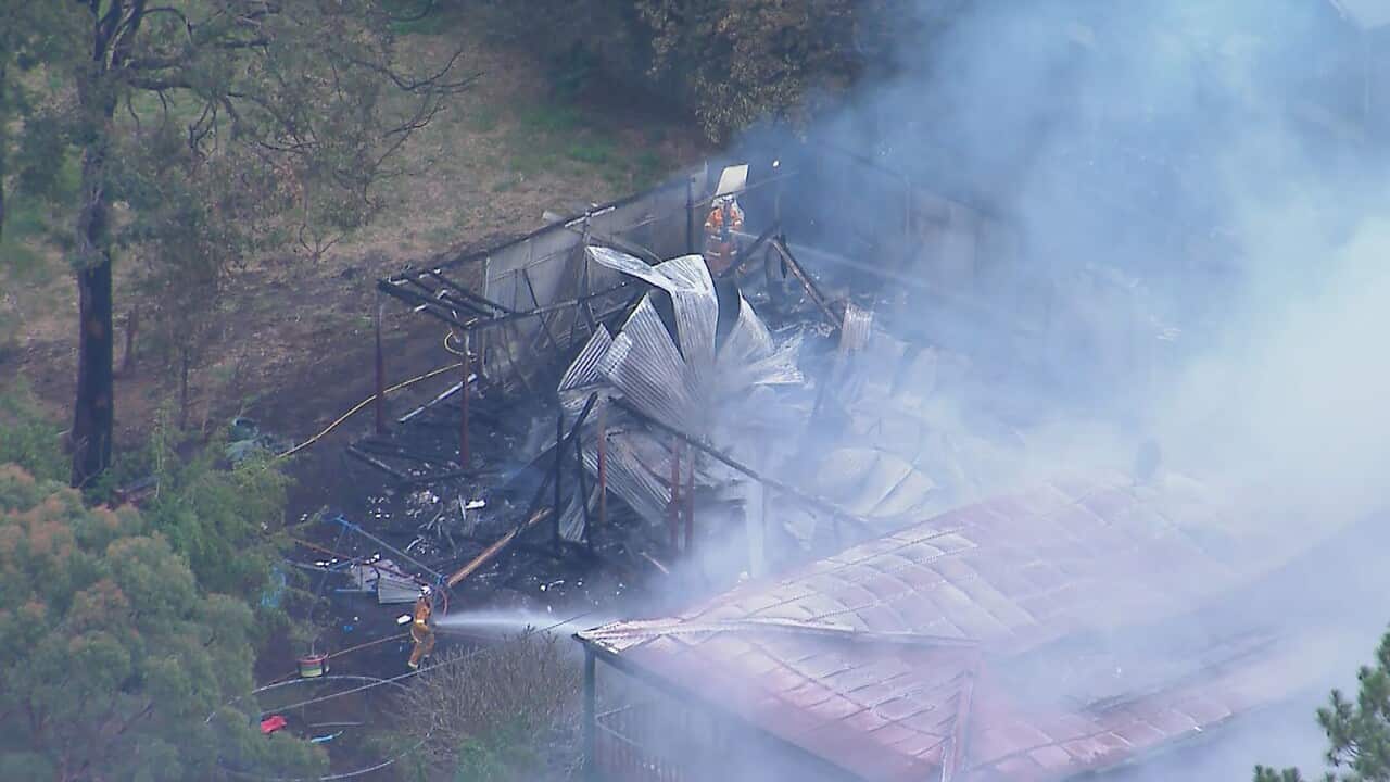 Firefighters extinguishing a fire at a house that has collapsed.