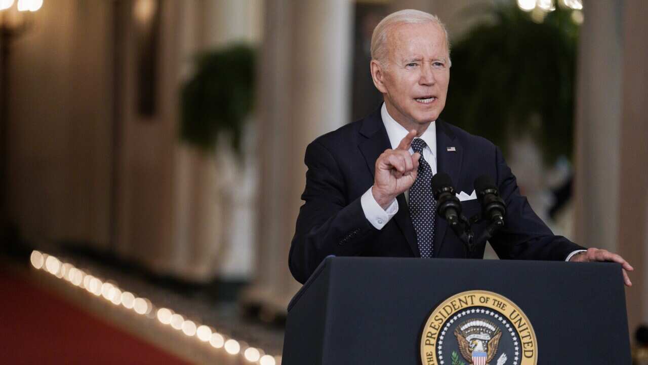 Joe Biden wearing a suit and standing at a lectern
