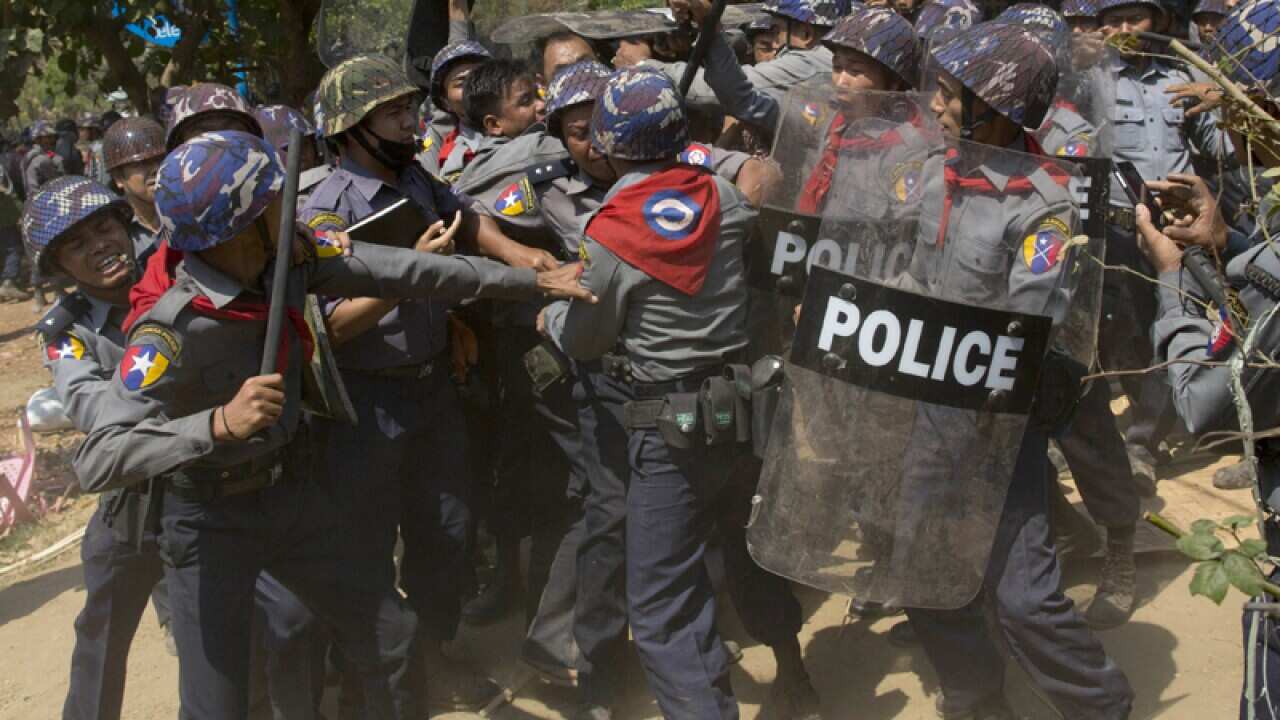 Police officers beat a student protester in Myanmar