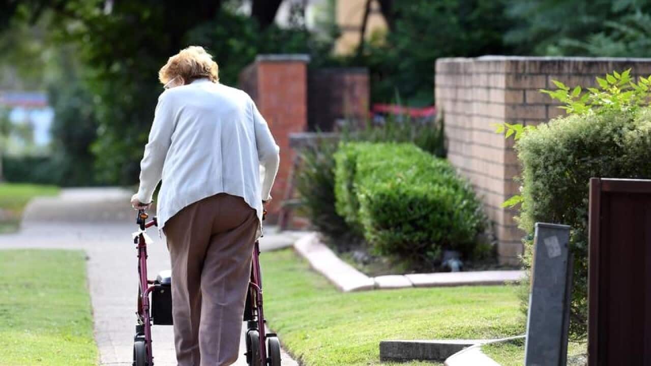 A file image of an elderly woman using a mobility walker