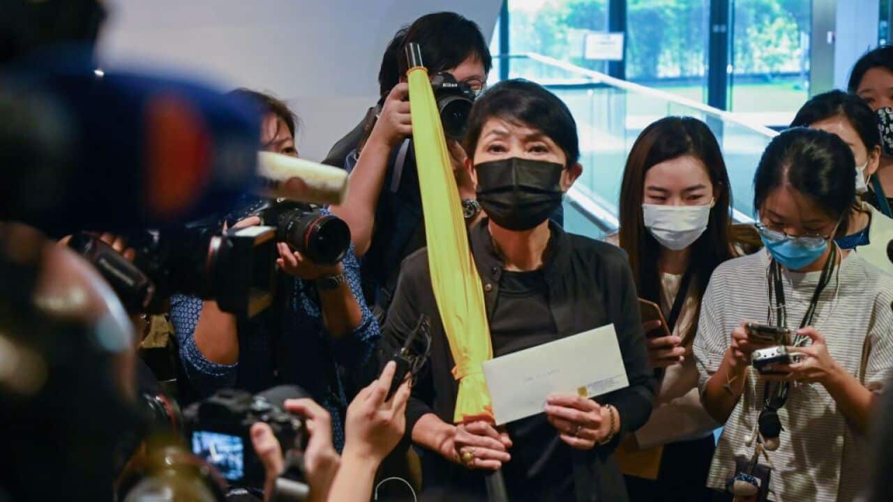 Pro-democracy lawmaker Claudia Mo holds a yellow umbrella and her resignation letter at the Legislative Council in Hong Kong on 12 November 2020.