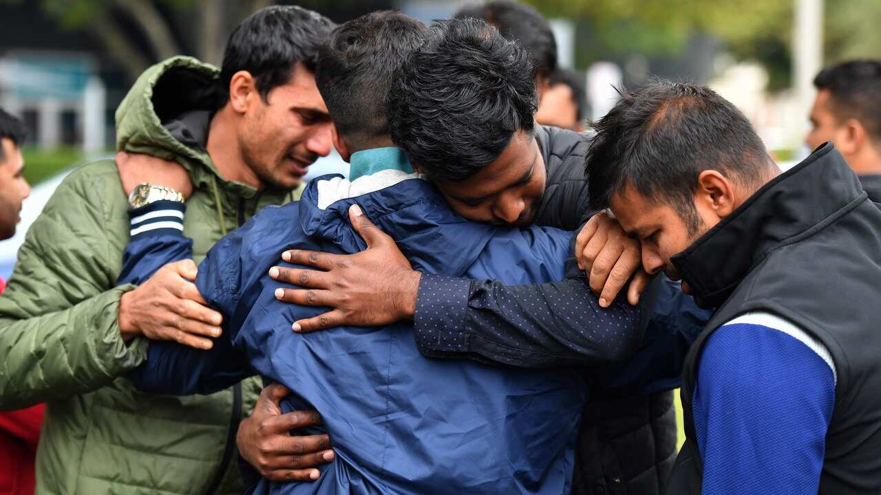 Friends of a missing man grieve outside a refuge centre in Christchurch.