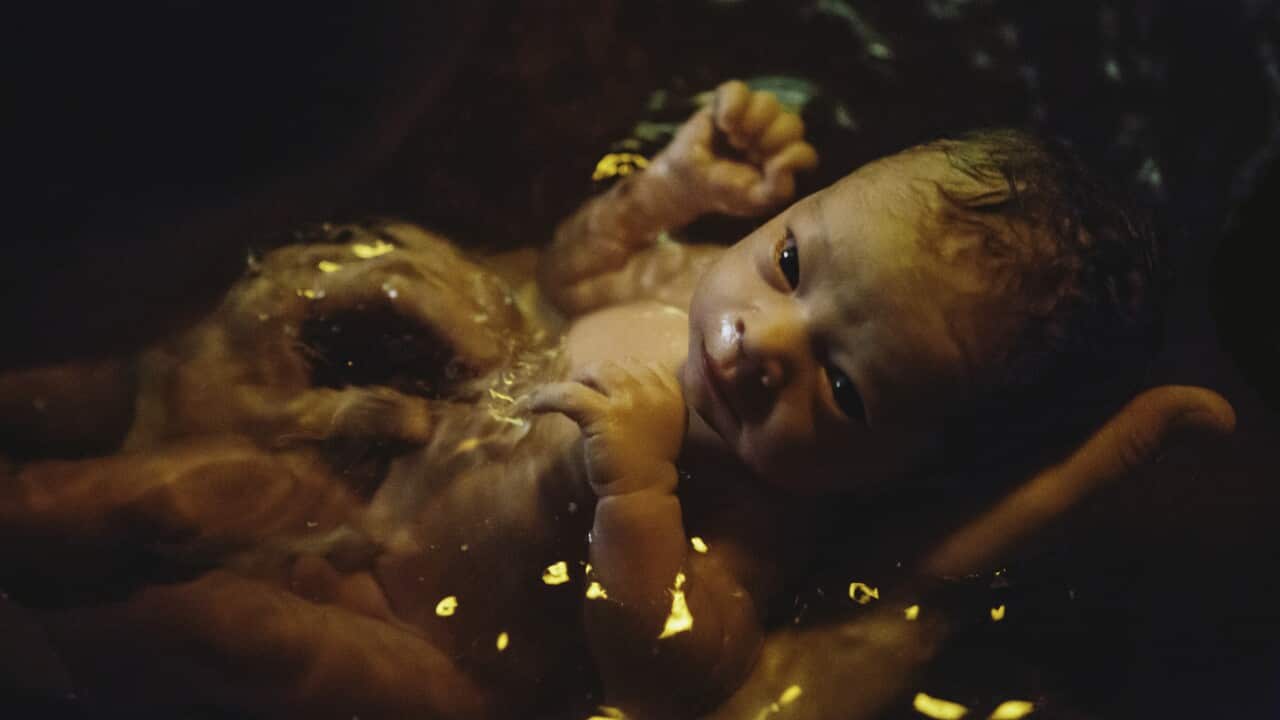 Newborn soaking in birthing pool