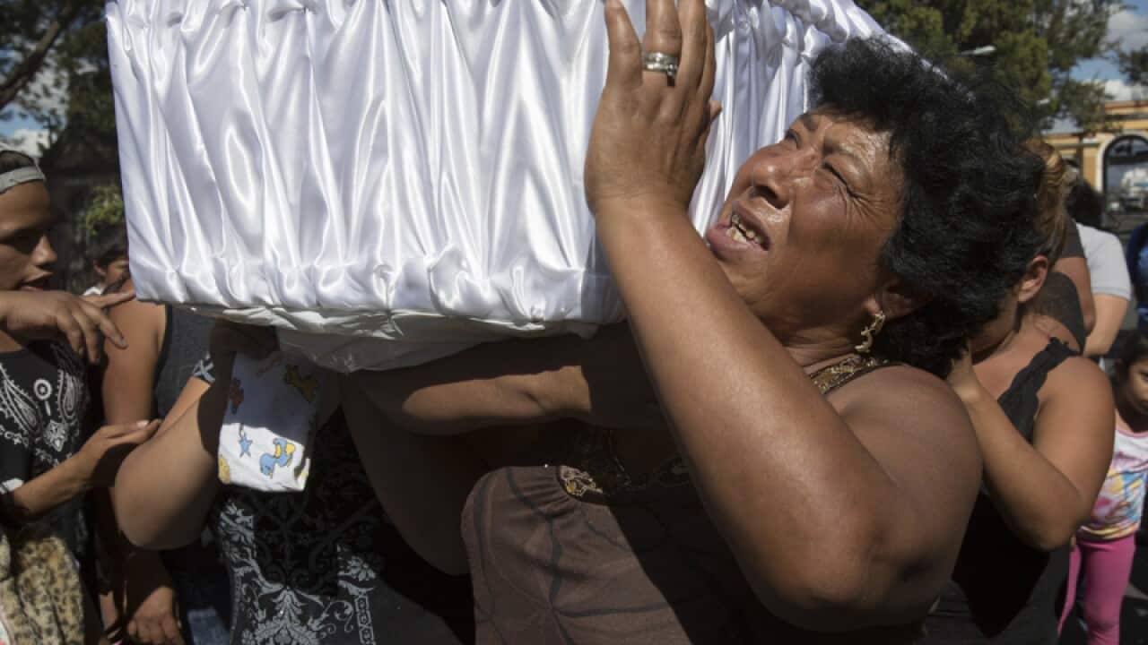 Women carry the coffin containing the remains of a 14-year-old girl