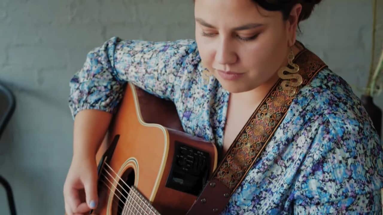 Gomeroi woman Loren Ryan playing the guitar.