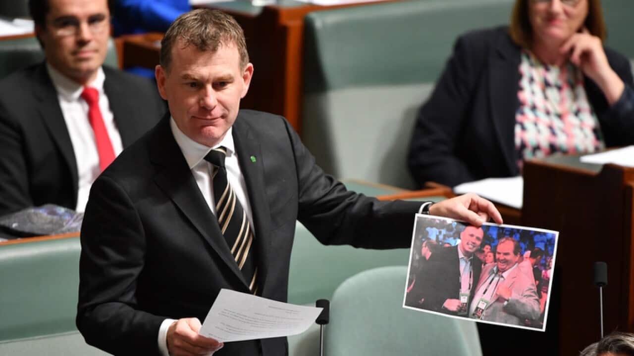 Labor MP Nick Champion holds a photo of Home Affairs Minister Peter Dutton and Helloworld CEO and federal Liberal Party treasurer Andrew Burnes