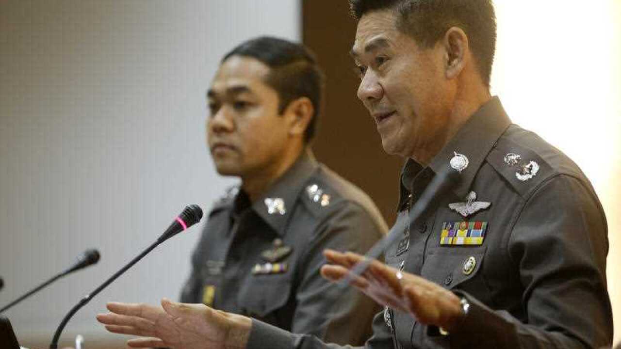 National police deputy spokesman Col. Songpol Wattanachai, right, gestures as he addresses a press conference in Bangkok