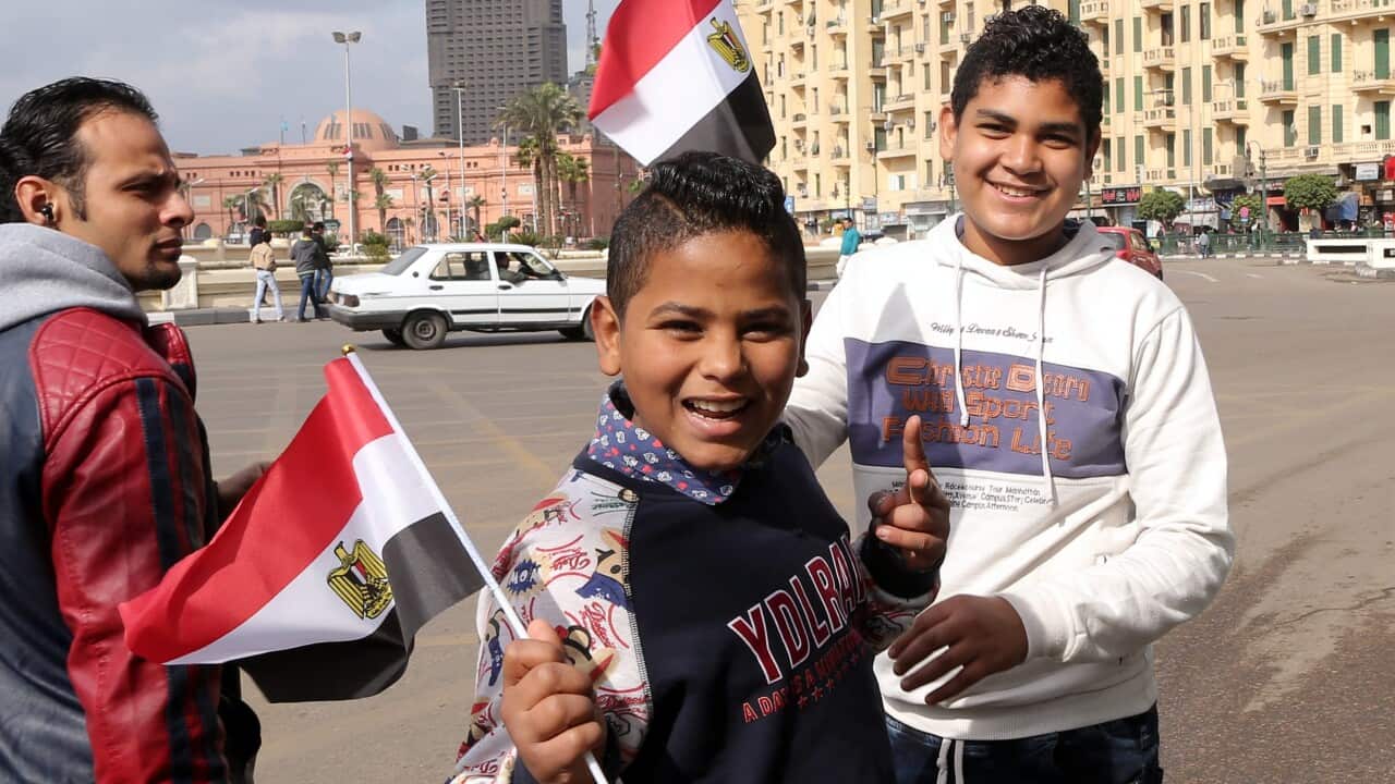 Youths hold Egyptian flags on Tahrir Square in Cairo, Egypt, 24 January 2016, on the eve of the fifth anniversary of the 25 January uprising. (EPA)