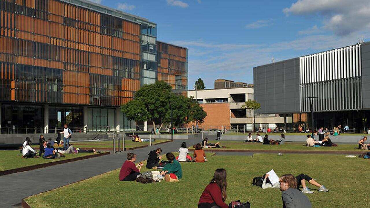 Students sit on the lawn near the Faculty of Law building at The University of Sydney, in Sydney on Wednesday, May 8, 2013. (AAP Image/Paul Miller) NO ARCHIVING