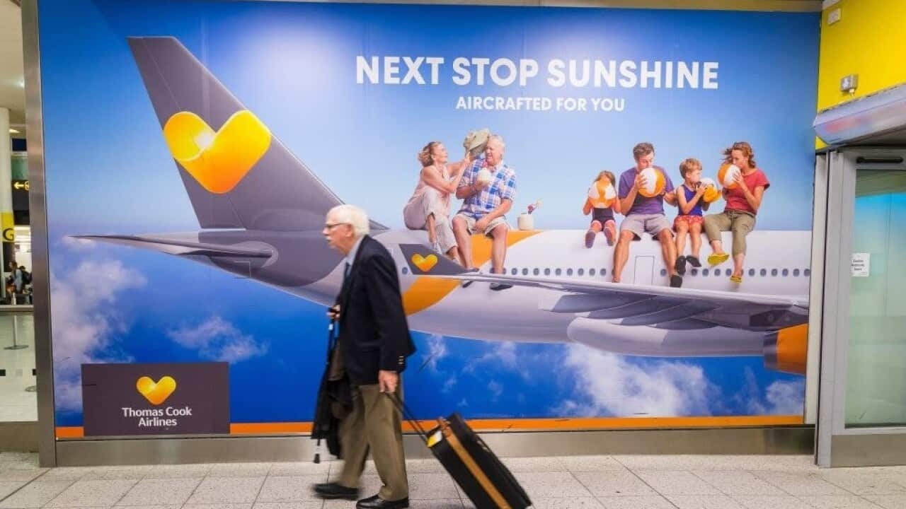 A man walks past a Thomas Cook advertising board at Gatwick Airport in Sussex, England