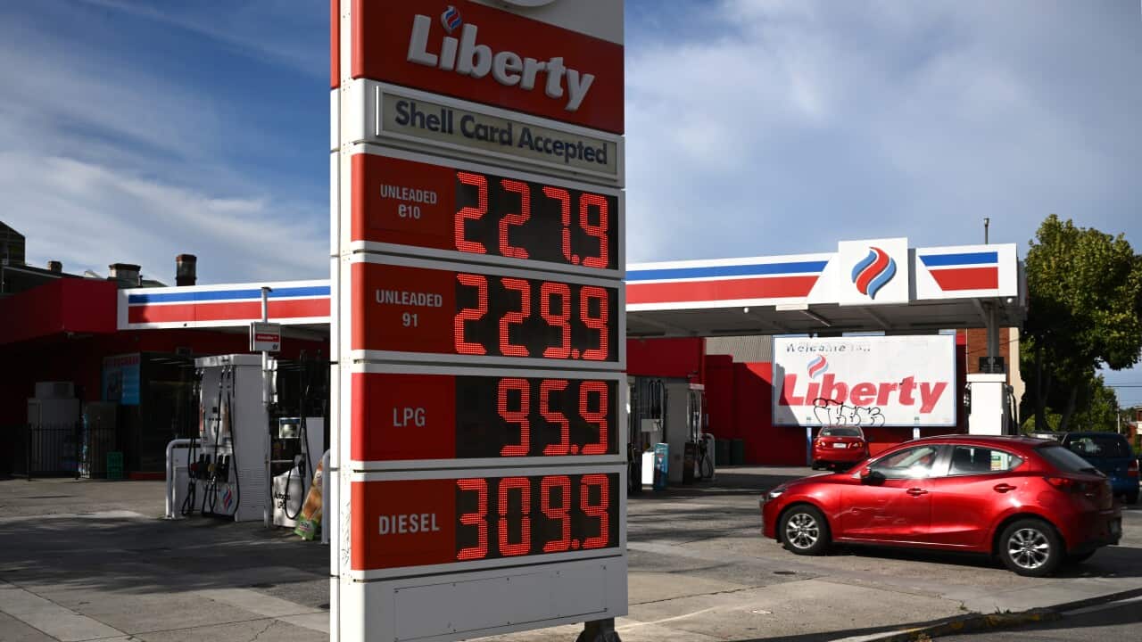 A digital fuel price sign at a Liberty gas station displays prices for Unleaded E10, Unleaded 91, LPG, and Diesel against a backdrop of the station's red and white branding and a parked red car.