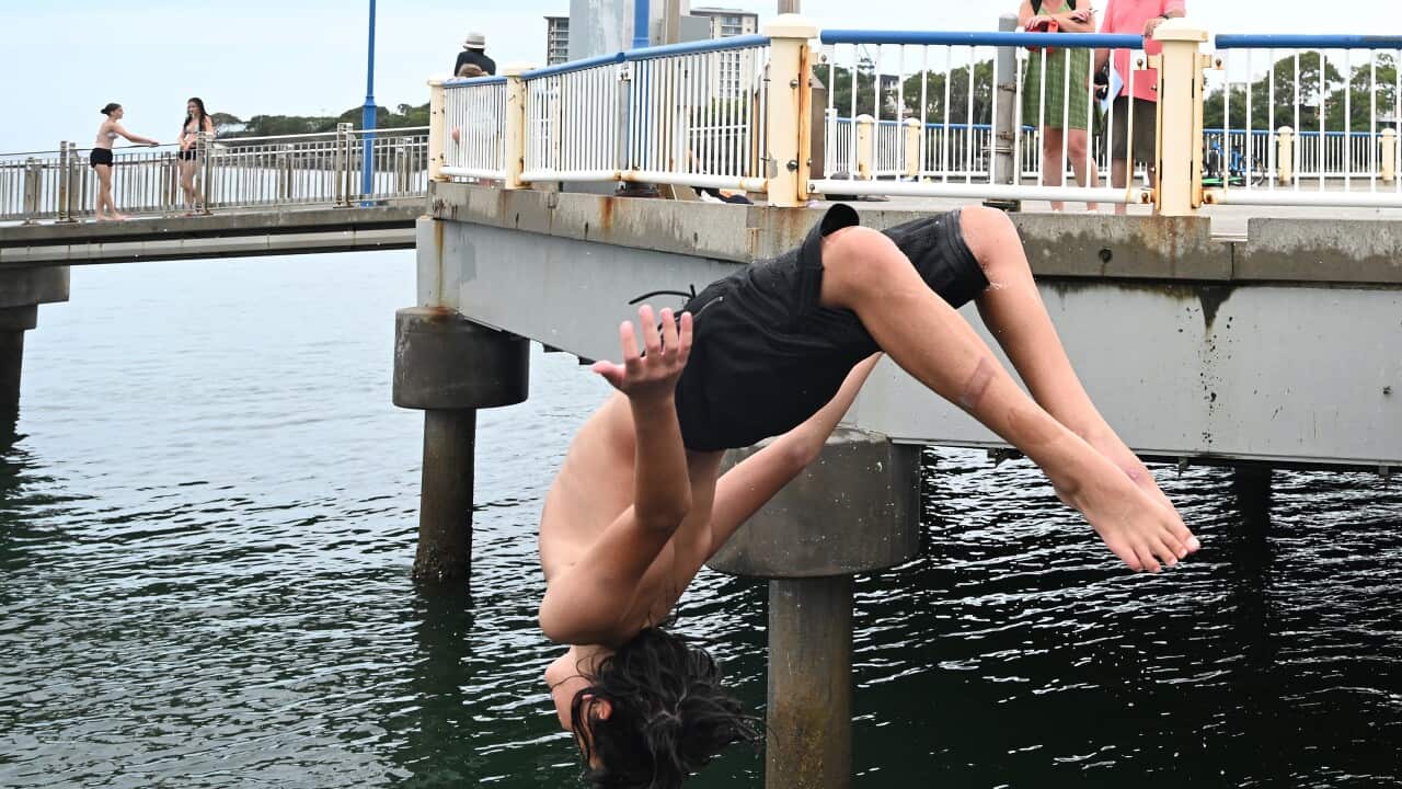 People are seen cooling off from the Redcliffe Jetty in Redcliffe, Queensland.
