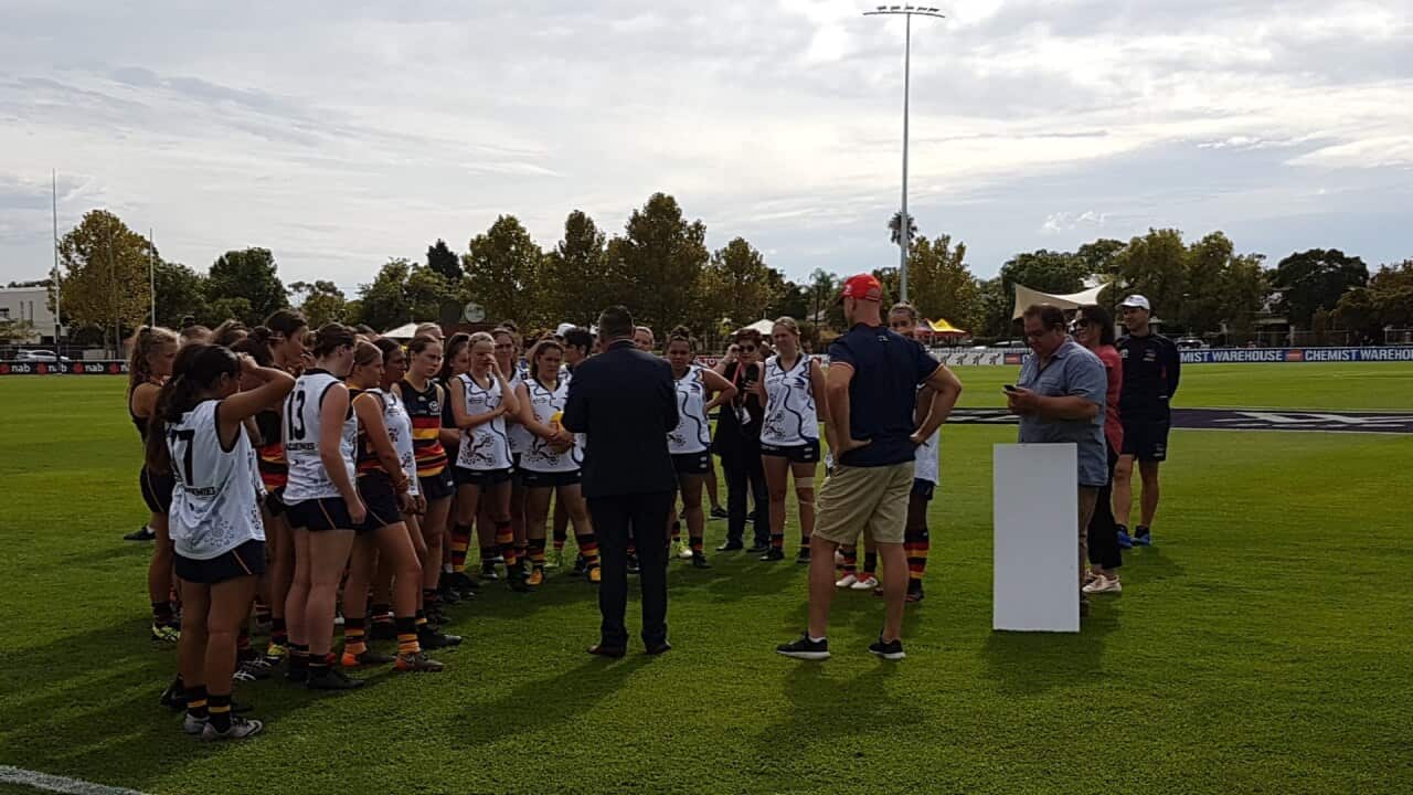 Women AFL players in a huddle at the break