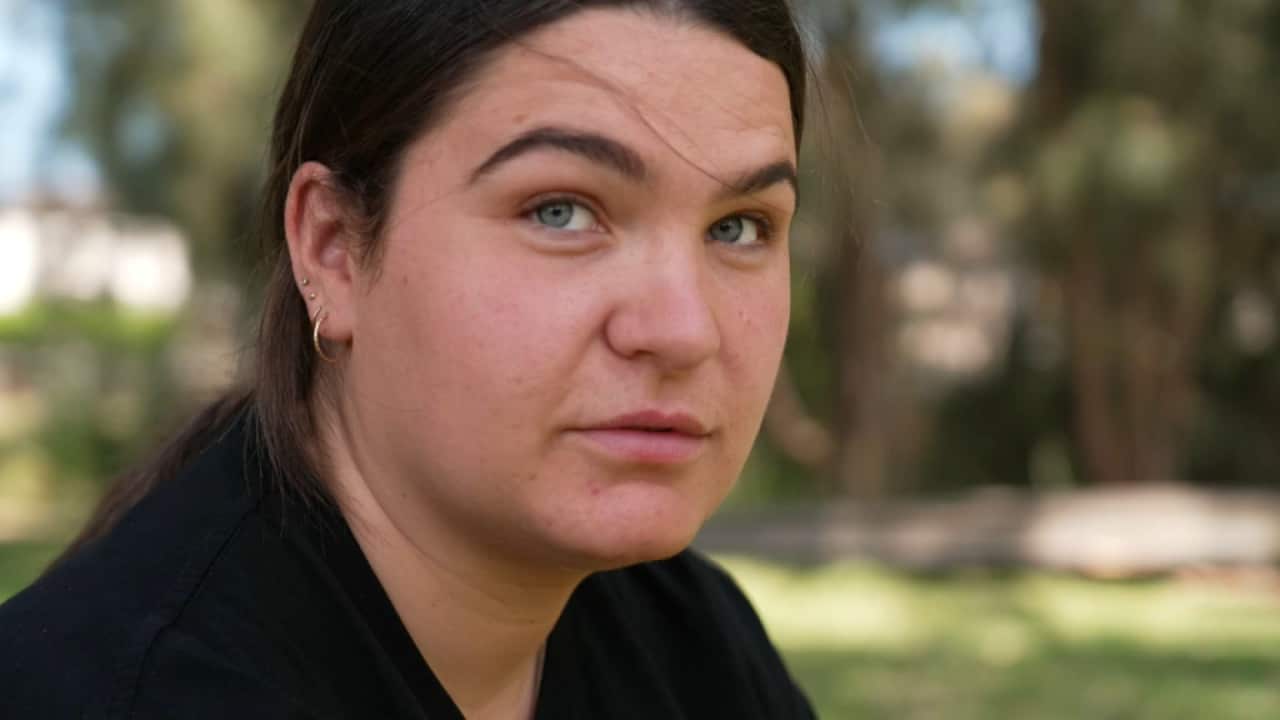 A young Dharawal, Ngarigo and Dungutti woman looks into the distance while at a park in Sydney.