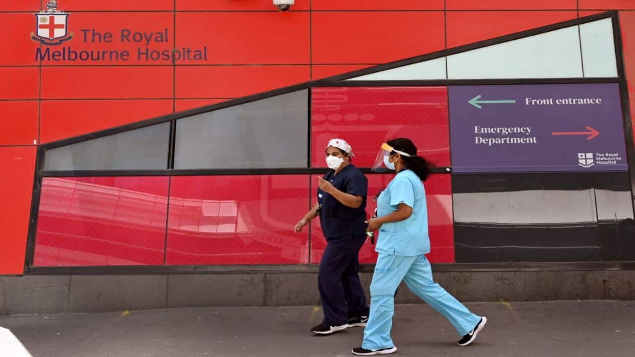 Medical staff walk past the emergency entrance at the Royal Melbourne Hospital in Melbourne on 9 October, 2021.