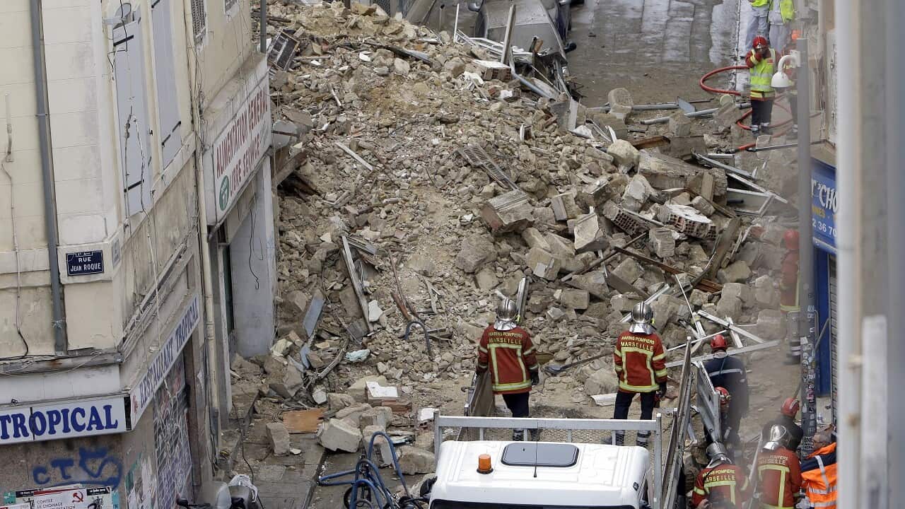 Firefighters work at the scene where a building collapsed In Marseille.