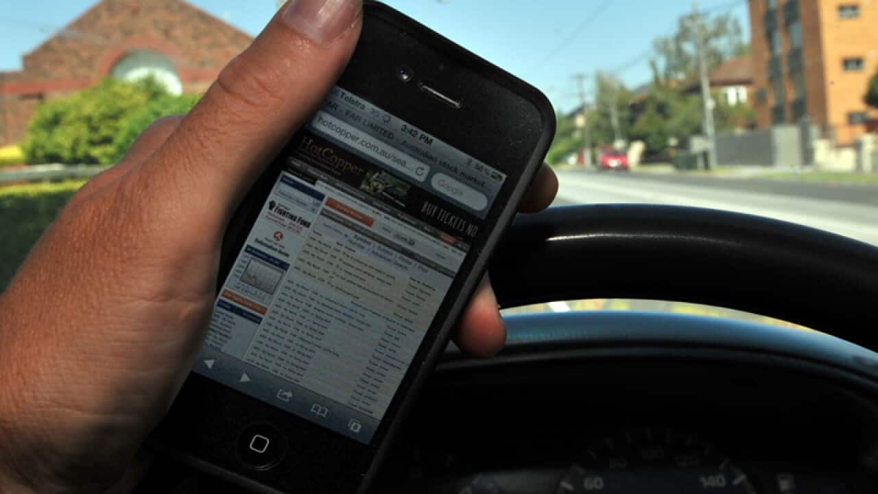A driver holds a mobile phone while driving