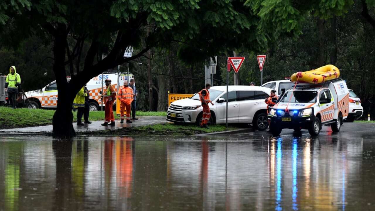 SES crews are seen as floodwater submerges the road on the corner of Ladbury Ave and Memorial Ave, in Penrith, NSW, Sunday, 21 March, 2021.