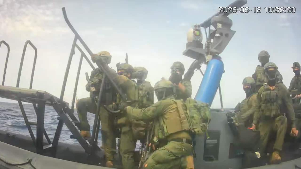 Masked men in military uniform standing on a large inflatable speedboat