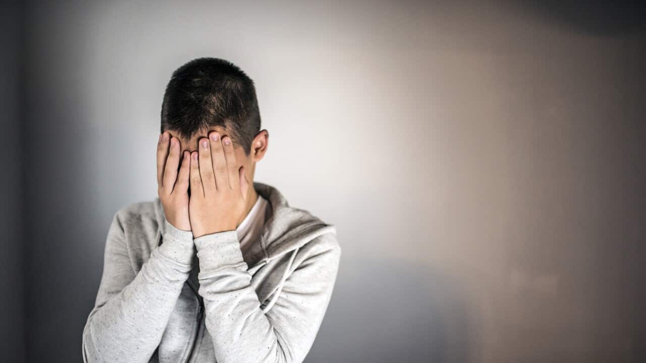 Photo of teenage boy wearing gray jacket against gray background
