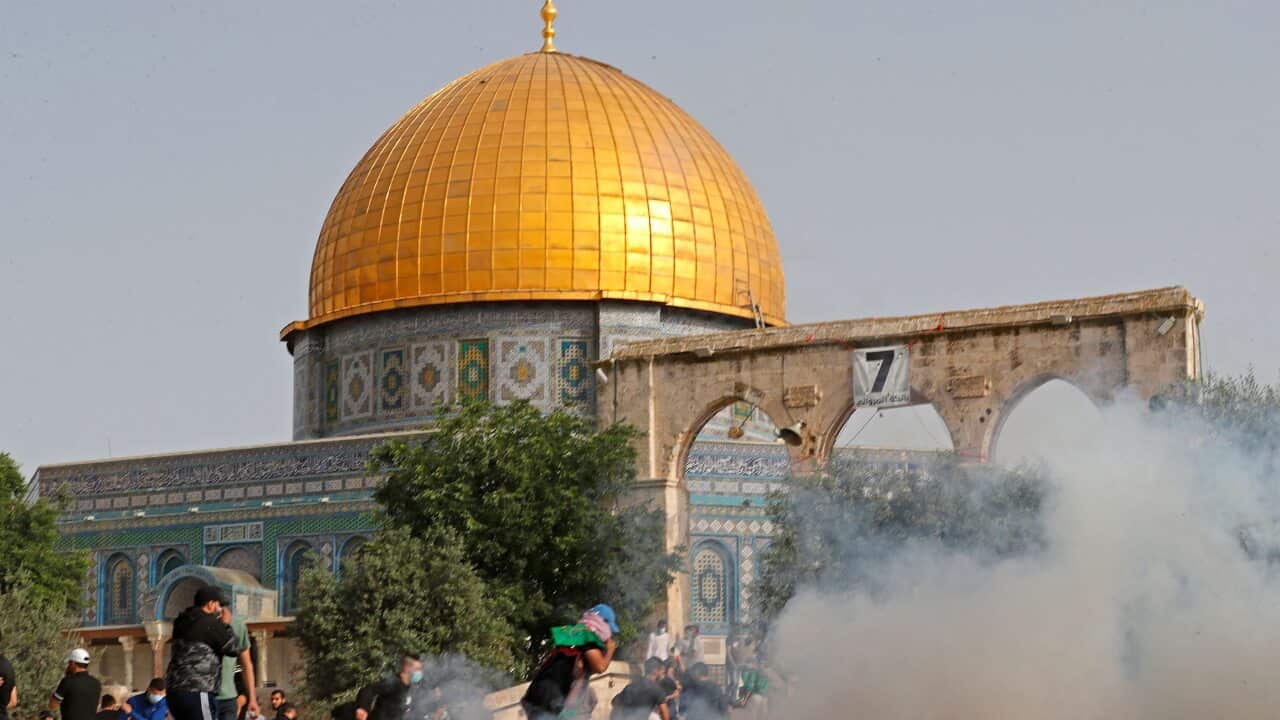 Palestinian protesters run for cover amid clashes with Israeli security forces at Jerusalem's Al-Aqsa mosque compound on 10 May, 2021.