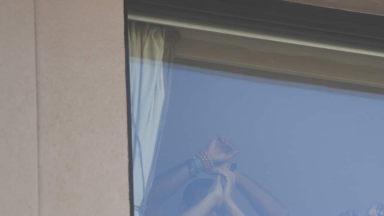 Refugees gesture towards protesters at the Park Hotel in Melbourne, Saturday, January 09, 2021. (AAP Image/Erik Anderson) NO ARCHIVING