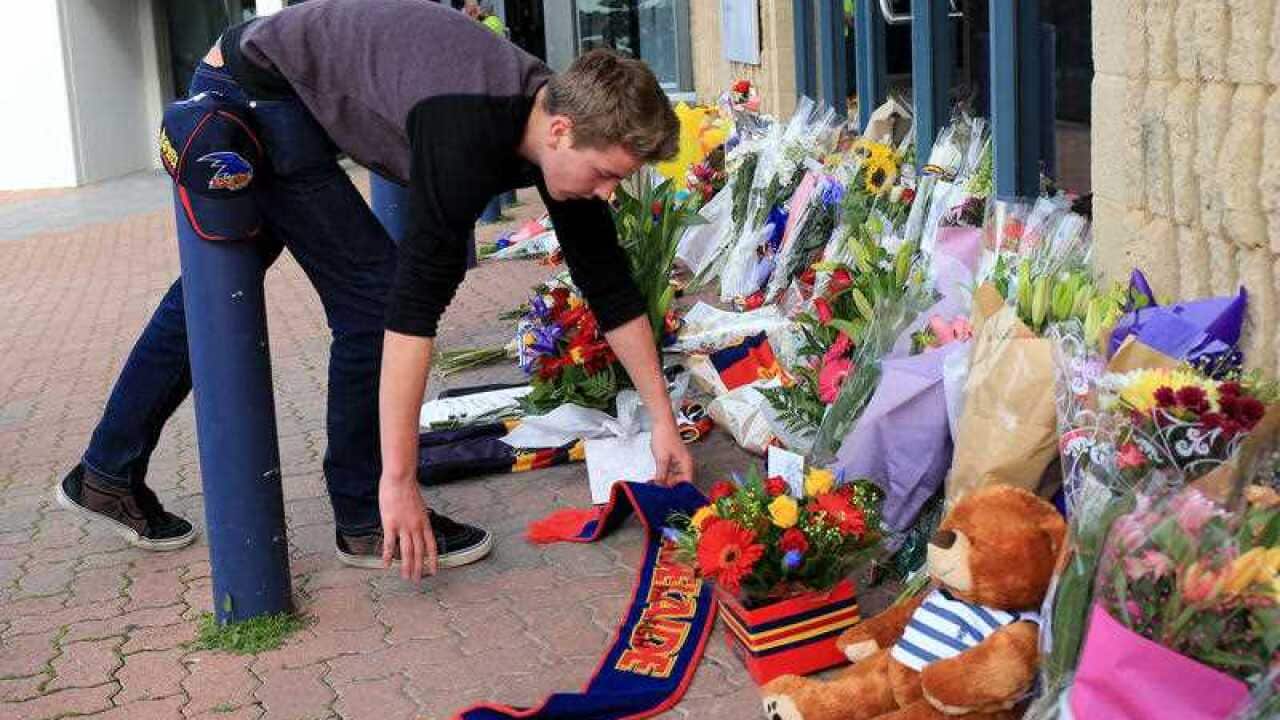 Adelaide Crows fans leave tributes at the football club headquarters at AAMI stadium.