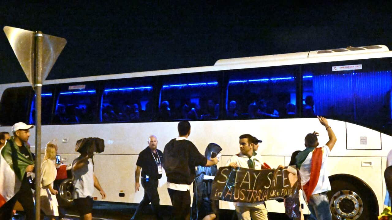 A group of protesters are seen around a bus transporting football players after a match.