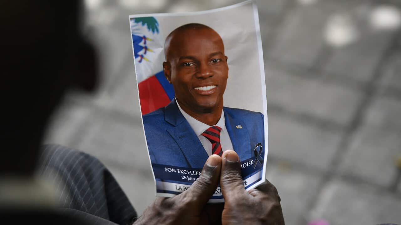 A person holds a photo of late Haitian President Jovenel Moise during his memorial ceremony, July 20, 2021.