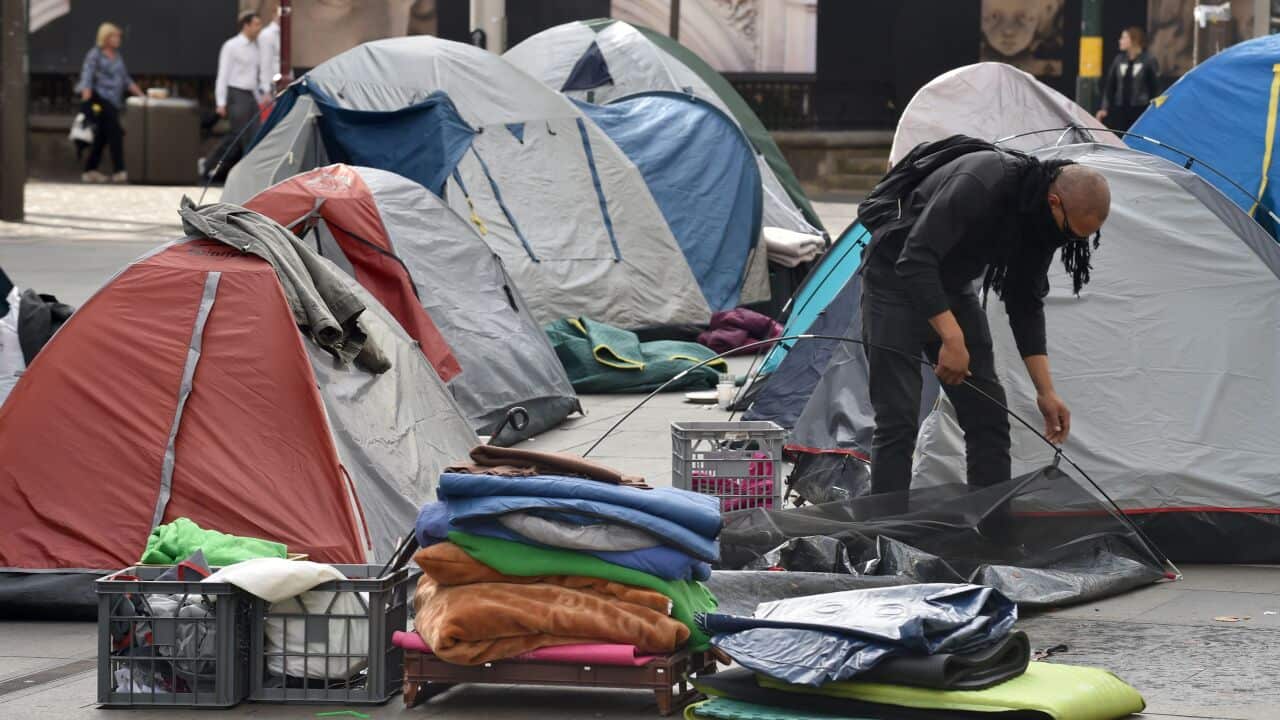 A homeless man packs up his tent in Sydney's Martin Place.